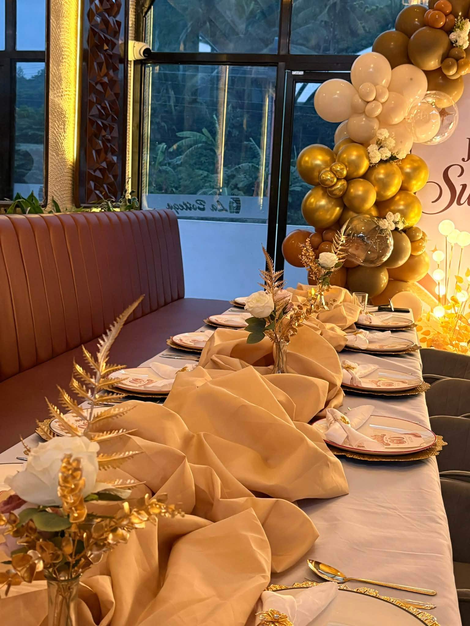 Long table with gold balloons and champagne runners set for a celebration