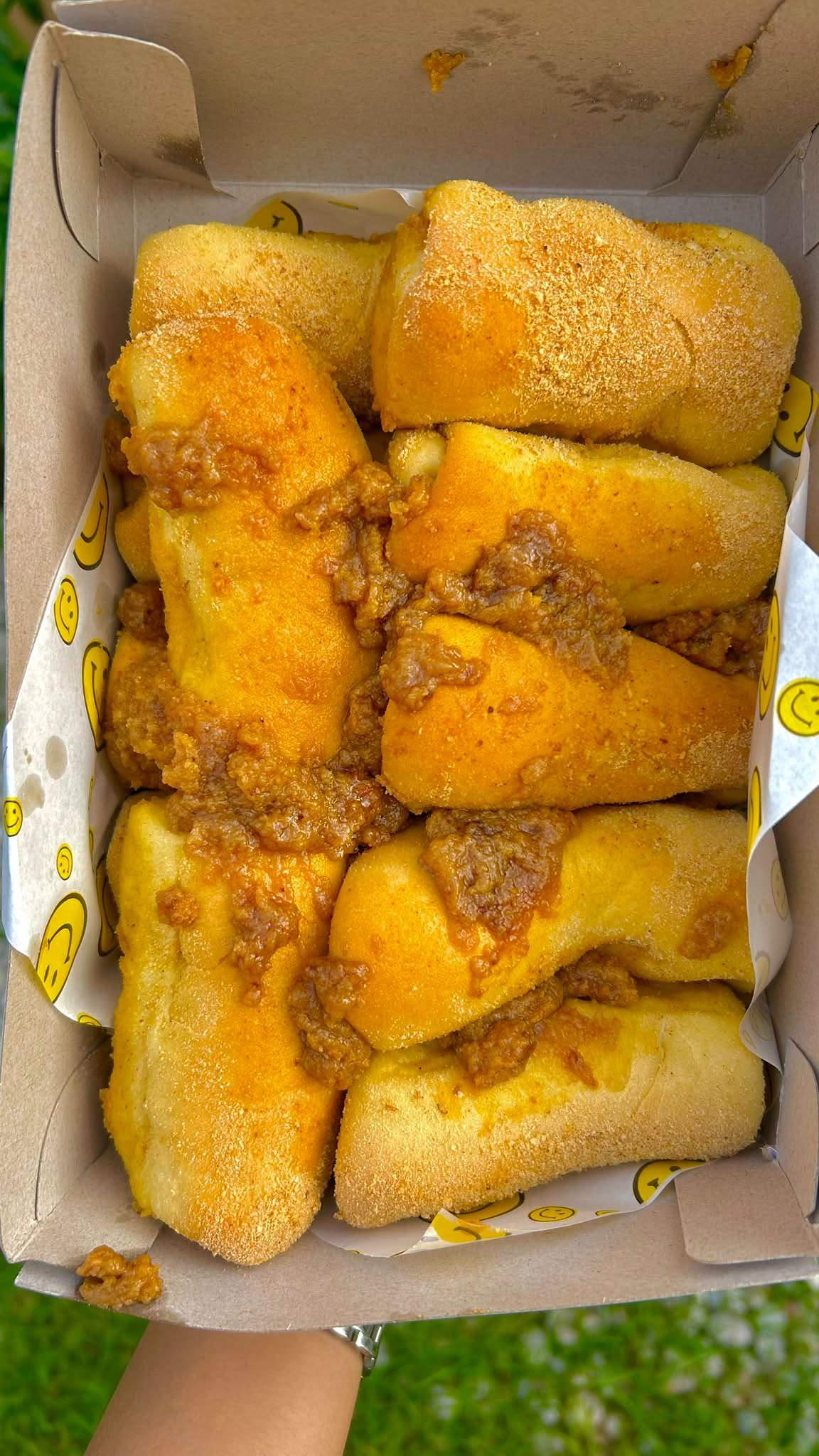 A box of golden baked rolls with a sweet crumb filling
